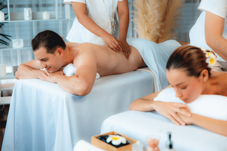 Caucasian couple customer enjoying relaxing anti-stress spa massage and pampering with beauty skin recreation leisure in day light ambient salon spa at luxury resort or hotel. Quiescentの写真素材