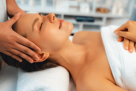 Caucasian woman enjoying relaxing anti-stress head massage and pampering facial beauty skin recreation leisure in dayspa modern light ambient at luxury resort or hotel spa salon. Quiescentの写真素材