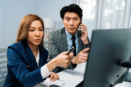 Businessman calling with business partner on mobile phone while calculating stock exchange value database with woman coworker on computer, analyzing company value sell or buy on up to date. Infobahn.の写真素材