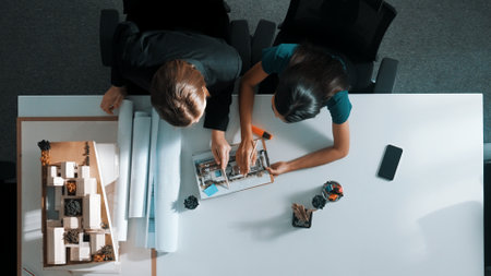 Top down aerial view of project manager walking at meeting table and start working. Aerial view of skilled architect engineer working together to plan building construction at meeting. Alimentation.の写真素材