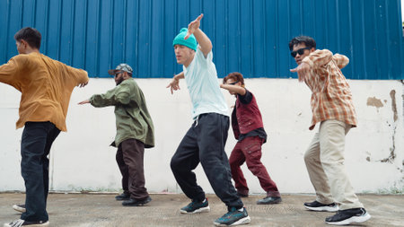 Group of hip hop choreographer dancing street dance together at wall. Young break dancer practicing break dance, moving to modern rhythm, express feeling of lively. Outdoor 2024. Hiphop.の写真素材