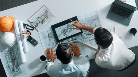 Top view of skilled civil engineer working together to plan building design. Top down aerial view of...