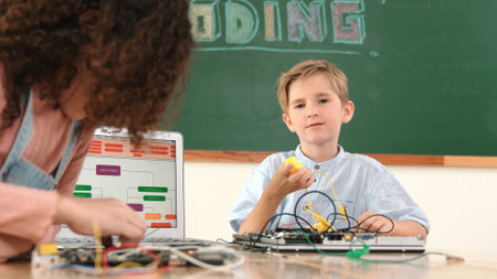 Caucasian smart boy fixing main board by using screwdriver at stem technology lesson while smiling...