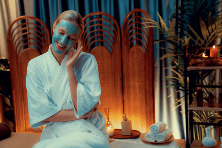 Serene ambiance of spa salon, woman customer indulges in rejuvenating with luxurious face cream massage with warm lighting candle. Facial skin treatment and beauty care concept. Quiescentの写真素材
