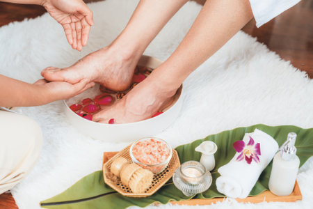 Woman indulges in blissful foot massage at luxurious spa salon while masseur give reflexology therapy in gentle day light ambiance resort or hotel foot spa. Quiescentの写真素材