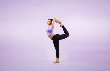 Full body length gaiety shot athletic and sporty woman doing healthy and meditative yoga exercise workout posture on isolated background. Healthy active and body care lifestyleの写真素材