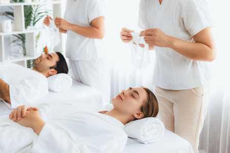 Serene modern daylight ambiance of spa salon, couple customer indulges in rejuvenating with facial skincare mask. Facial skin treatment and beauty cosmetology procedure for face. Quiescentの写真素材