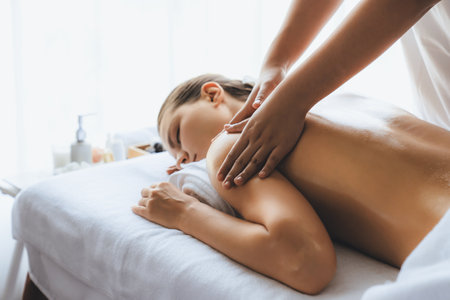 Caucasian woman customer enjoying relaxing anti-stress spa massage and pampering with beauty skin recreation leisure in day light ambient salon spa at luxury resort or hotel. Quiescentの写真素材