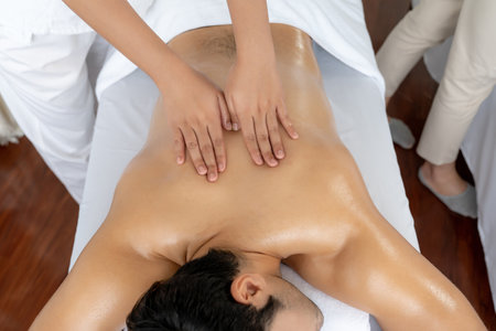 Top view man customer enjoying relaxing anti-stress spa massage and pampering with beauty skin recreation leisure in day light ambient salon spa at luxury resort or hotel. Quiescentの写真素材