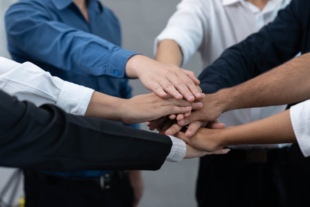 Group of diverse office worker join hand together in office room symbolize business synergy and...