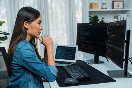 Young Asian IT developer looking online information on pc for beautiful pose with coding program data of website application, wearing jeans shirt. surround by safety analysis two screens. Stratagem.の写真素材