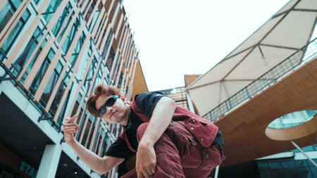 Low angle of asian attractive hipster pose at camera surround by mall. Portrait of break dance choreographer looking at camera while dancing in hip hop style. Outdoor sport 2024. Hiphop.の写真素材