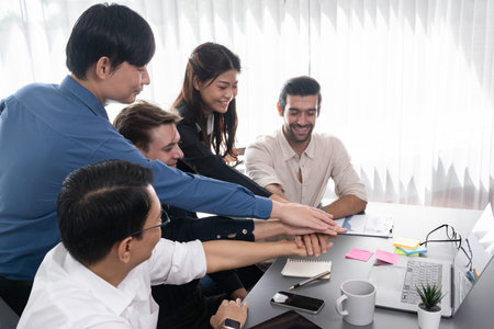 Group of diverse office worker join hand together in office room symbolize business synergy and...