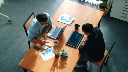 Skilled project manager walking at table while colleague brainstorm idea. Business team working together to plan marketing strategy while looking at data analysis or financial statistic. Convocation.の写真素材