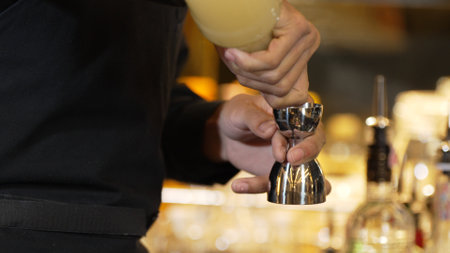 Closeup mixing hand bartender holding jigger to measure sugar salt all of ingredients into shaker...