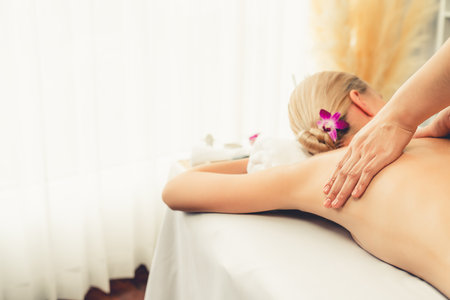 Caucasian woman customer enjoying relaxing anti-stress spa massage and pampering with beauty skin recreation leisure in day light ambient salon spa at luxury resort or hotel. Quiescentの写真素材