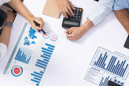 Diverse corporate audit team or company bookkeeper and accountant consultant calculate account expenses and income budget for tax refunds using calculators in top view busy workspace. Prudentの写真素材