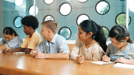 Smart boy listening teacher explain while lecturing and think about idea. Diverse student study or...