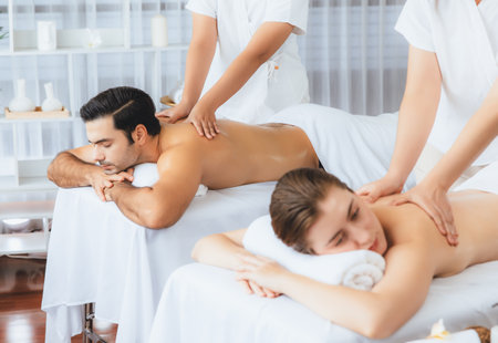 Caucasian couple customer enjoying relaxing anti-stress spa massage and pampering with beauty skin recreation leisure in day light ambient salon spa at luxury resort or hotel. Quiescentの写真素材