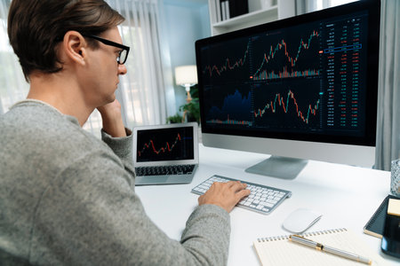 Business trader using computer and laptop to search highest profit value of dynamic increased stock...