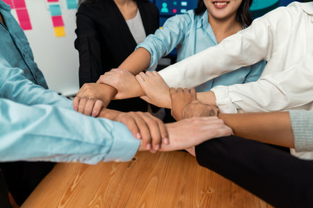 Multicultural business people holding hand together in circle. Unity teamwork in office business workplace. Diverse ethnic office worker engaged in team building. Meticulousの写真素材