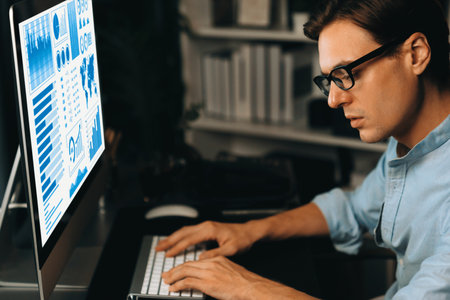 Smart businessman analyzing business paragraph dynamic database marketing analysis plan surrounded paper sheet and pc monitor report to compare with document data at home office at night. Pecuniary.の写真素材