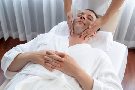 Caucasian man enjoying relaxing anti-stress head massage and pampering facial beauty skin recreation leisure in dayspa modern light ambient at luxury resort or hotel spa salon. Quiescentの写真素材