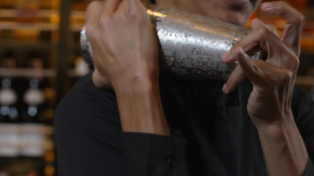 Closeup Asian bartender shaking mixed all ingredients alcohol liquor and syrup tasty with shaker presentation in special refresh drink showcasing nightlife mixology at luxurious nightclub. Vinosity.の写真素材