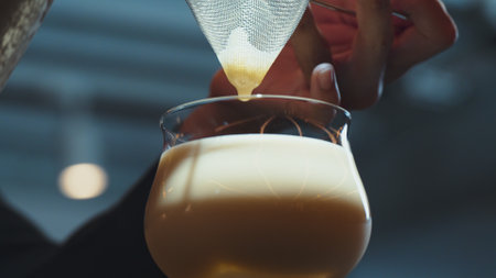 Closeup hand bartender using strainer in all ingredients alcohol liquor and syrup tasty in cocktail glass serving special refresh drink showcasing nightlife mixology at luxurious nightclub. Vinosity.の写真素材