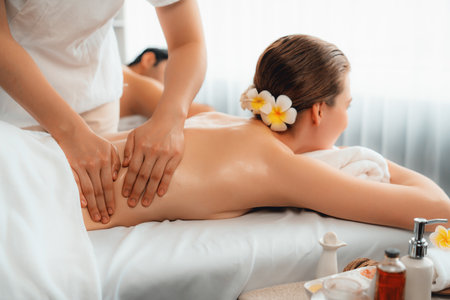 Caucasian couple customer enjoying relaxing anti-stress spa massage and pampering with beauty skin recreation leisure in day light ambient salon spa at luxury resort or hotel. Quiescentの写真素材