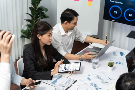 Analyst team utilizing BI Fintech to analyze financial data at table in meeting room. Businesspeople analyzing BI dashboard power on paper for business insight and strategic marketing planning.Prudentの写真素材
