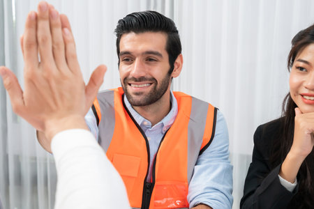 Diverse group of civil engineer and client celebrate and high five after make successful agreement...
