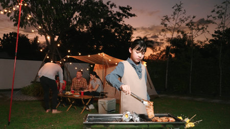 Family gather celebrate holiday, Adorable child grill food for family member. Outdoor camping activity to relax with tasty meal and spend time with young generation cross generation gap. Divergence.の写真素材