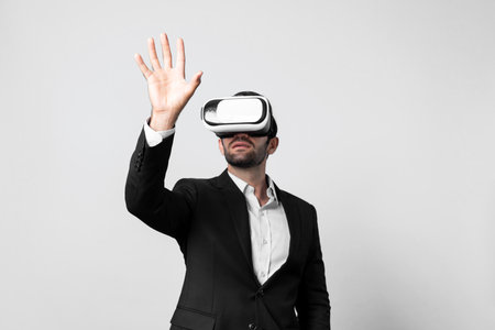 Professional smart business man holding something while wearing VR glasses. Caucasian project...