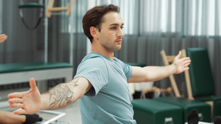A person performing an arm extension exercise in a fitness studio setting. The movement demonstrates...