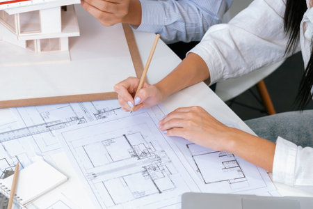 Professional male engineer hand measure house model by using ruler while beautiful cooperative...