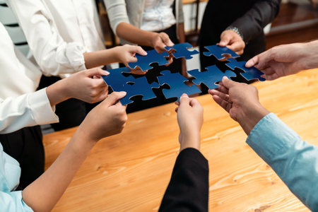 Multiethnic business people holding jigsaw pieces and merge them together as effective solution solving teamwork, shared vision and common goal combining diverse talent. Meticulousの写真素材