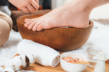 Woman indulges in blissful foot massage at luxurious spa salon while masseur give reflexology therapy in gentle day light ambiance resort or hotel foot spa. Quiescentの写真素材