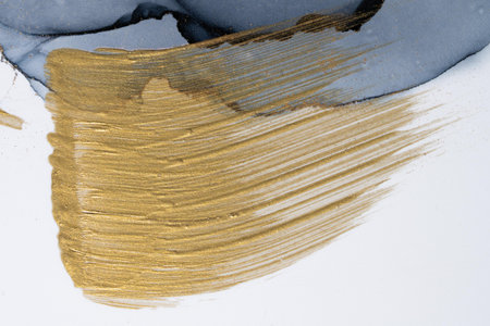 Hand drawn brush stroke gold paint stain texture on paper. High resolution photo taken from original artwork painting.の写真素材