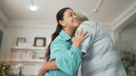Happy grandfather and grandmother with casual cloth holding hand and dancing together at home. Lovely senior couple moving to music and spending time together while supporting at kitchen. Myrmidon.の写真素材