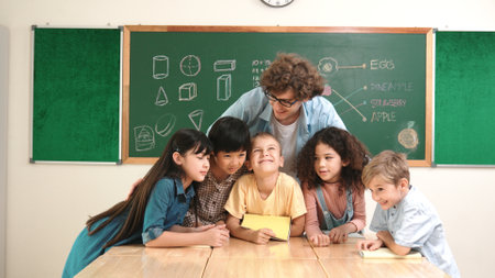 Caucasian smart teacher and diverse student looking at camera at classroom. Group of happy children smiling while instructor hug to encourage and standing in front of black board. Education. Pedagogy.の写真素材