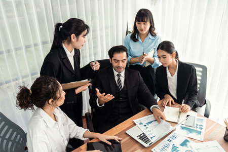 Diverse group of business analyst team analyzing financial data report paper on office table. Chart and graph dashboard by business intelligence analysis for strategic marketing planning Meticulousの写真素材