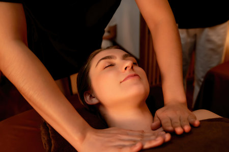 Caucasian woman customer enjoying relaxing anti-stress spa massage and pampering with beauty skin recreation leisure in warm candle lighting ambient salon spa at luxury resort or hotel. Quiescentの写真素材