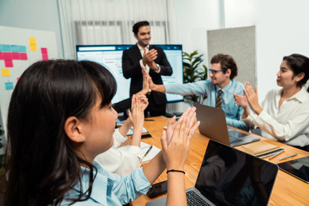 Cheerful meeting room, businesspeople celebrate with high fives and applause. Successful project was...