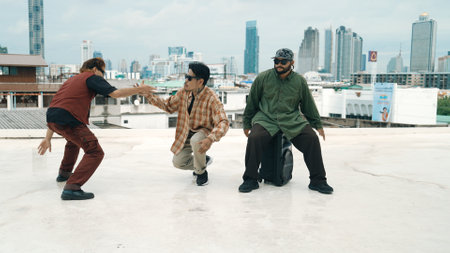 Professional break dance team practice B-boy dance while multicultural friends at rooftop. Young modern dancing group doing hip hop movement. Style,fashion,action. Outdoor sport 2024. Hiphop.の写真素材
