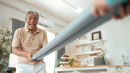 Elderly man playing a ball rolling game with his partner at home, practicing hand-eye coordination,...