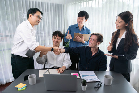 Diverse group of office employee worker shake hand after making agreement on strategic business marketing meeting. Teamwork and positive attitude create productive and supportive workplace. Prudentの写真素材