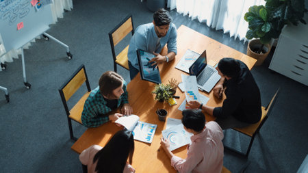 Skilled project manager walking at table while colleague brainstorm idea. Business team working together to plan marketing strategy while looking at data analysis or financial statistic. Convocation.の写真素材