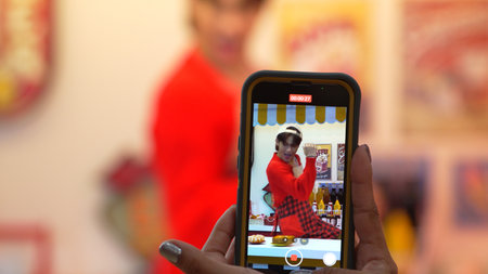 Customer record video of restaurant worker dancing and holding food tray at modern bar with food....