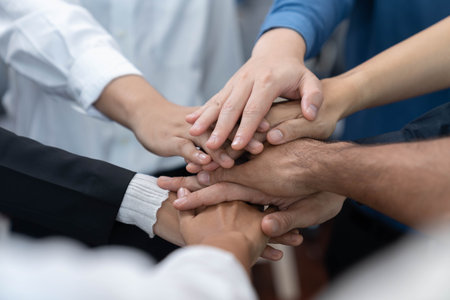 Group of diverse office worker join hand together in office room symbolize business synergy and strong productive teamwork in workplace. Cooperation and unity between business employee. Prudentの写真素材